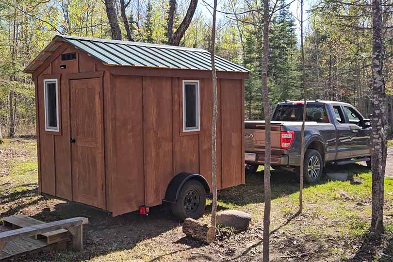 A Minnesota Mobile Sauna is delivered to its home nestled in the woods.